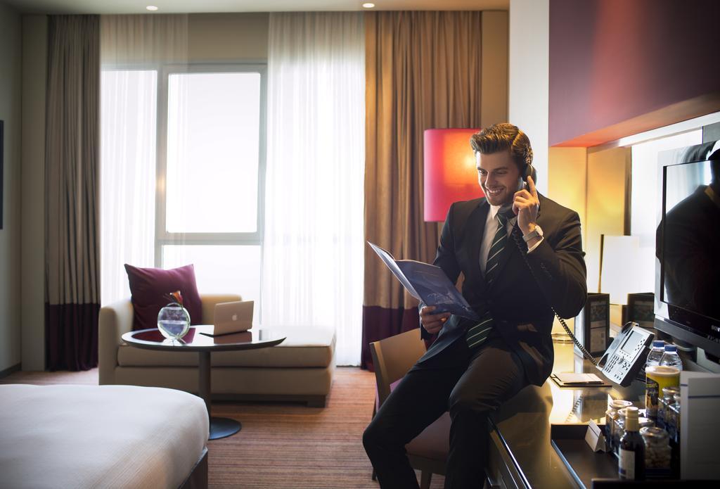 Park Rotana Abu Dhabi Hotel Exterior photo A business traveller in a hotel room